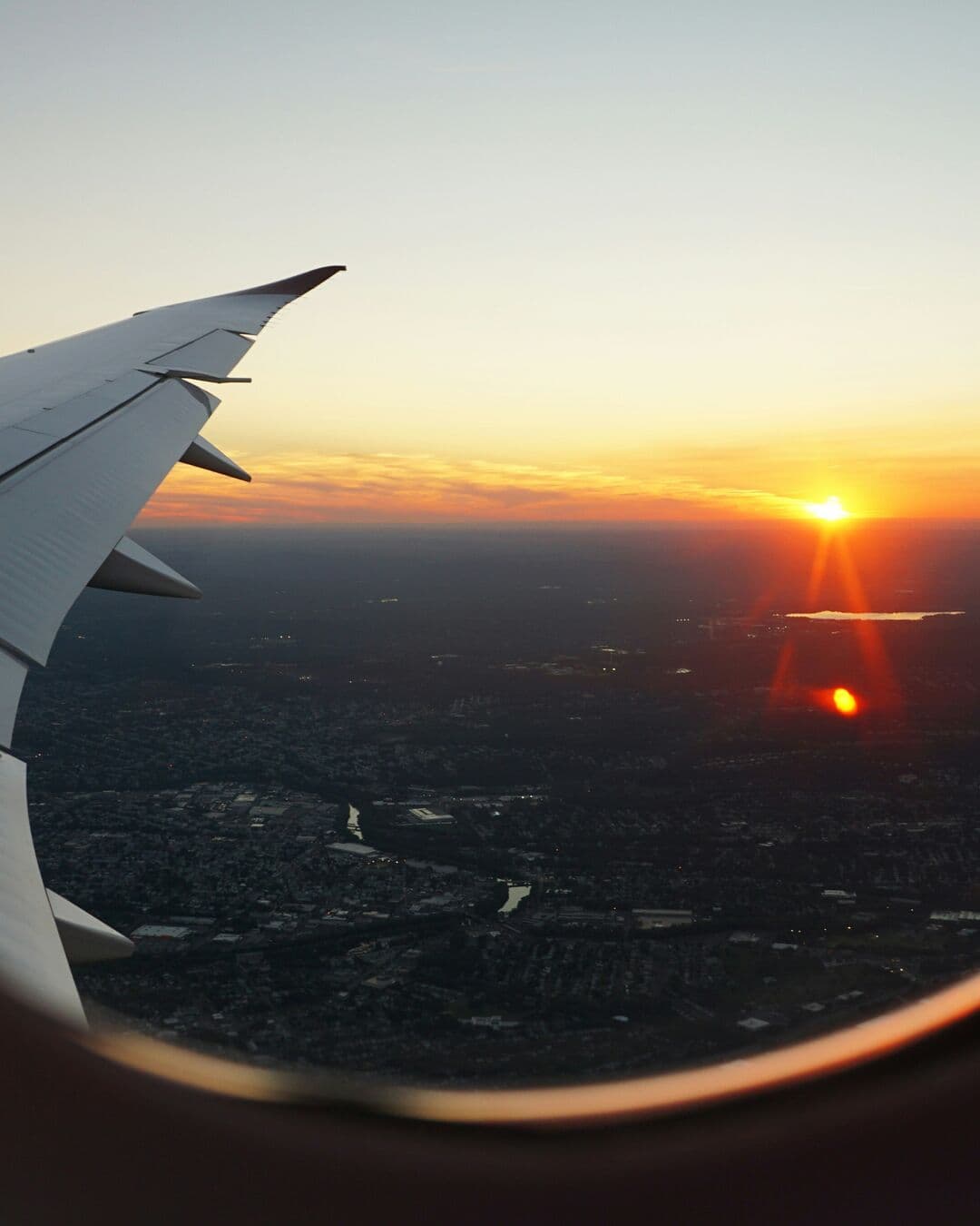 Hopscotch Travel video ad frame — sunset over an aircraft wing